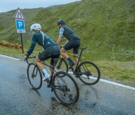 a couple of people riding bikes down a road